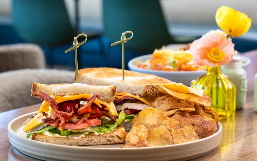Chicken Club Sandwich at Early Birds restaurant Las Vegas, stacked with grilled chicken, cheddar cheese, bacon, lettuce, tomato, and ranch aioli on sourdough. Best Chicken Club Sandwich near Enterprise.